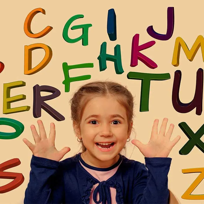 A cheerful young girl with raised hands is surrounded by colorful 3D letters on a beige background.