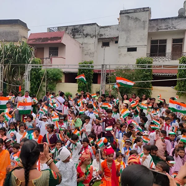 Crowd of school children and teachers waving Indian flags during a vibrant Independence Day celebration